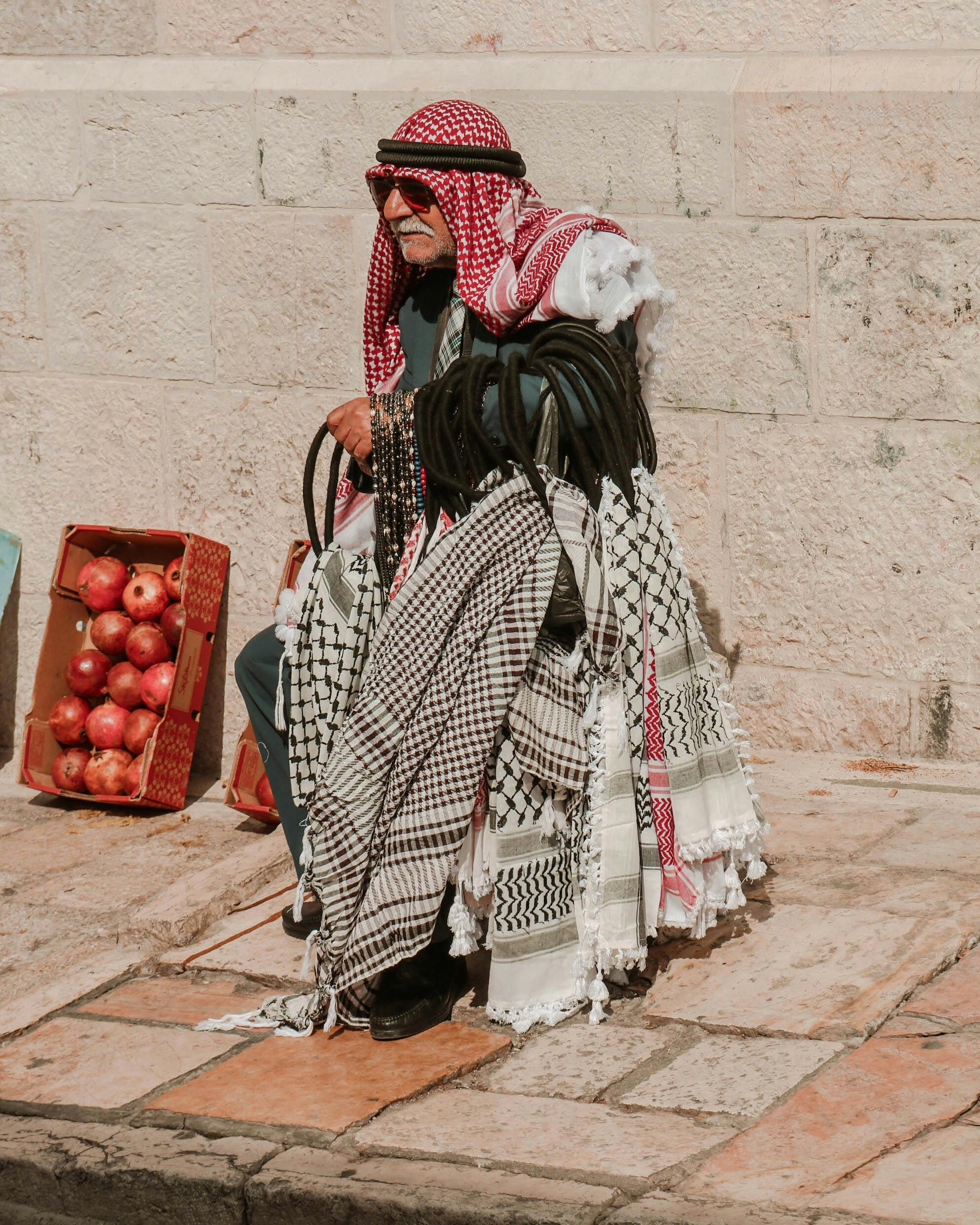 A woman embroiders a piece of fabric with traditional Palestinian Tatreez, a core symbol of cultural identity.